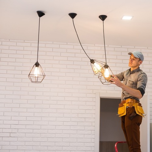 An Electrician Works on Light Fixtures